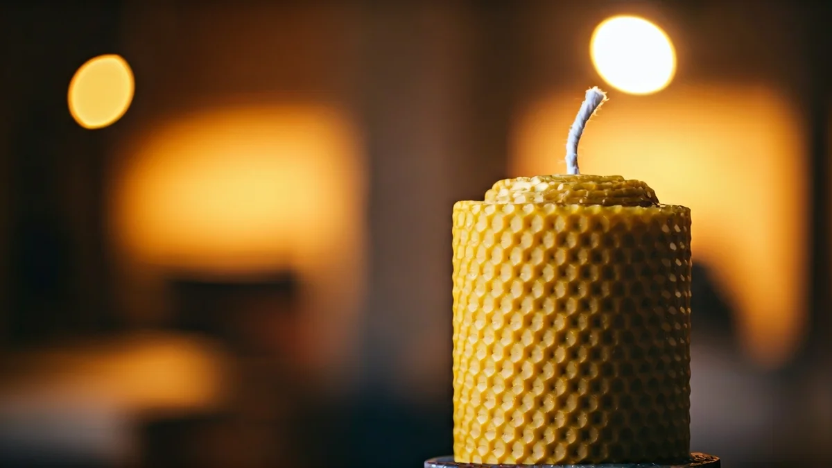 Imaxe xenérica dunha vela artesanal de cera de abella nun obradoiro.