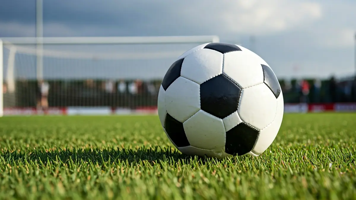 Imaxe xenérica dun balón de fútbol sobre a herba dun campo.