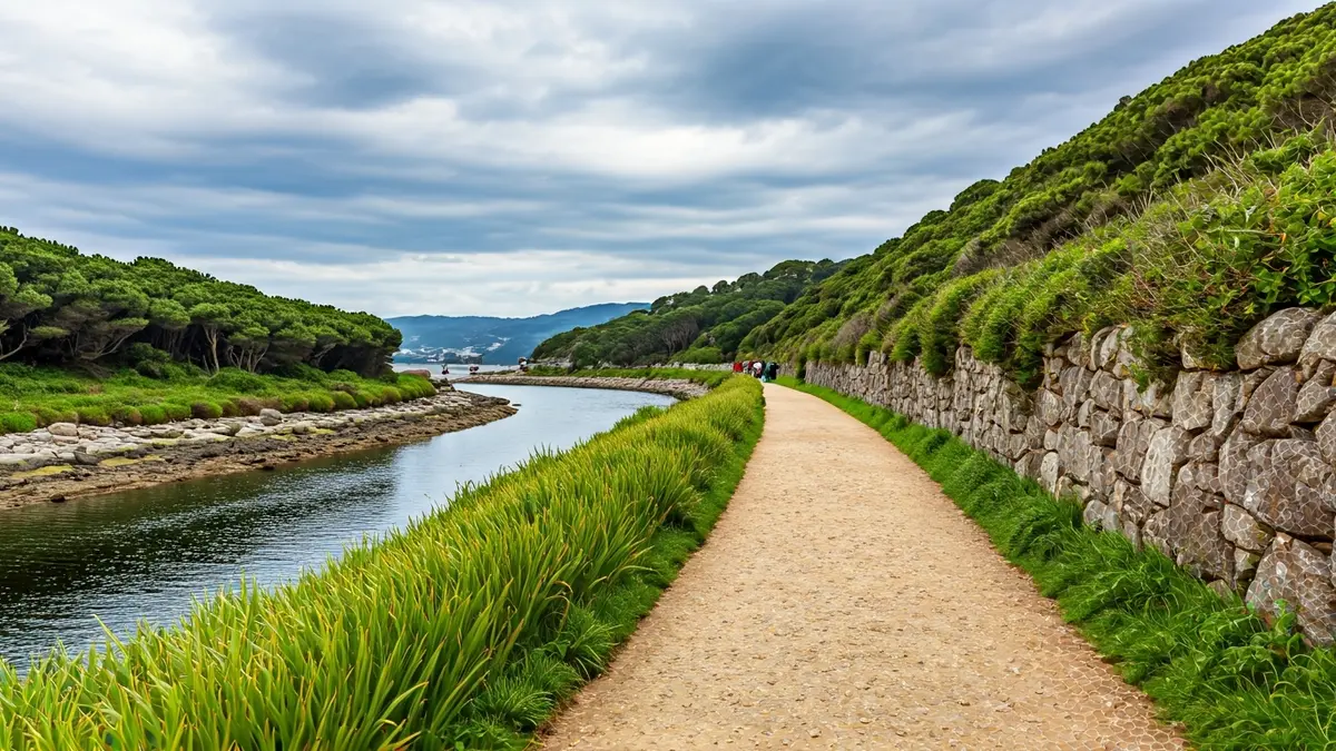 Senda costera en Galicia, con vegetación y elementos de piedra tradicionales.