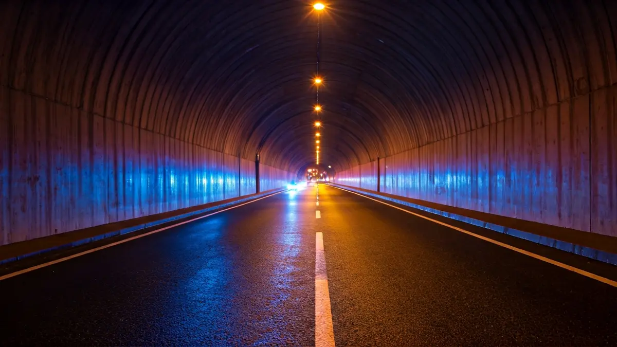 Imagen genérica de luces de emergencia reflejándose en el asfalto mojado a la entrada de un túnel.