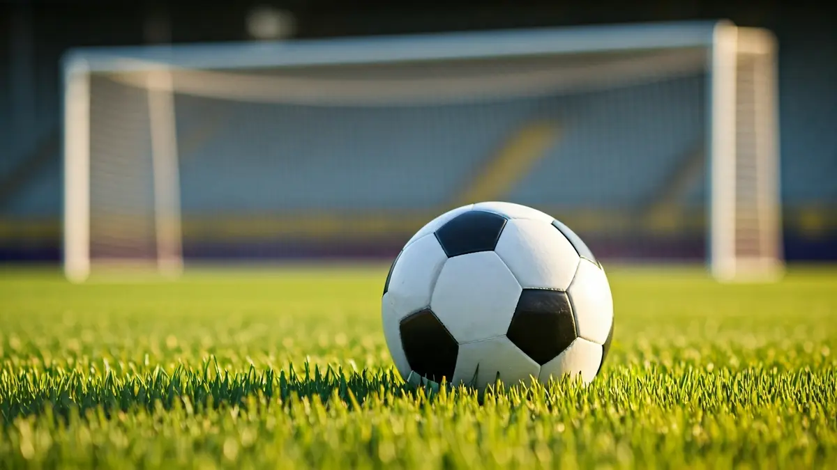 Imaxe xenérica dun balón de fútbol sobre o céspede dun campo.