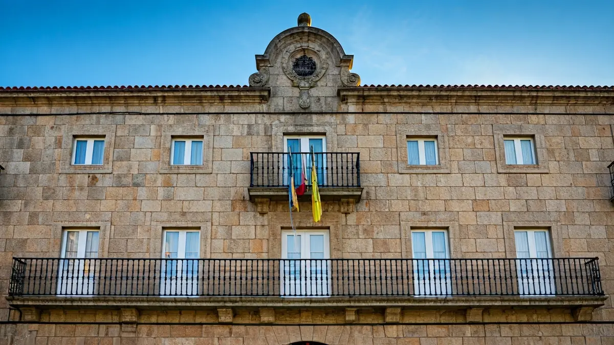 Fachada de pedra do concello de Carballo baixo a luz do sol.