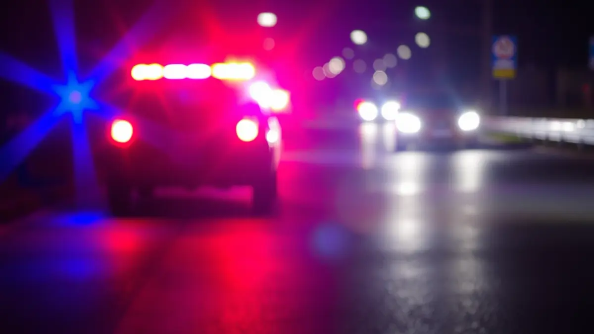 Imagen genérica de luces de emergencia reflejadas sobre asfalto mojado.