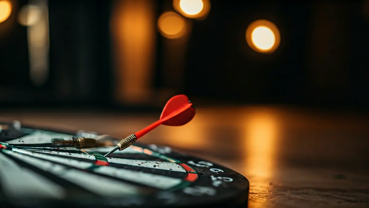 Imaxe xenérica dunha diana con varios dardos cravados, nun ambiente de recreo.