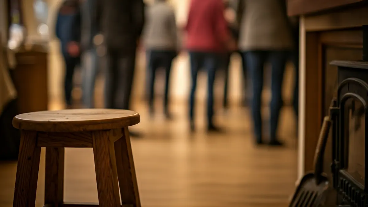 Imaxe xenérica dun taburete de madeira e unha pa de cheminea no chan.