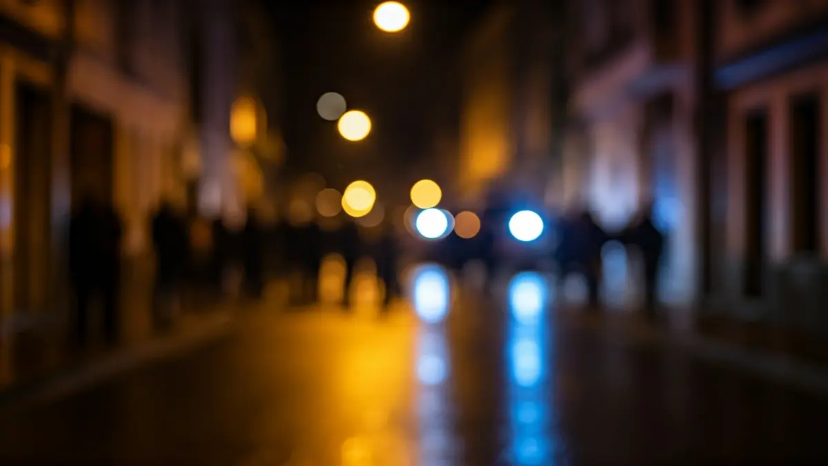 Imaxe xenérica de luces de emerxencia reflectíndose nunha rúa mollada de noite.