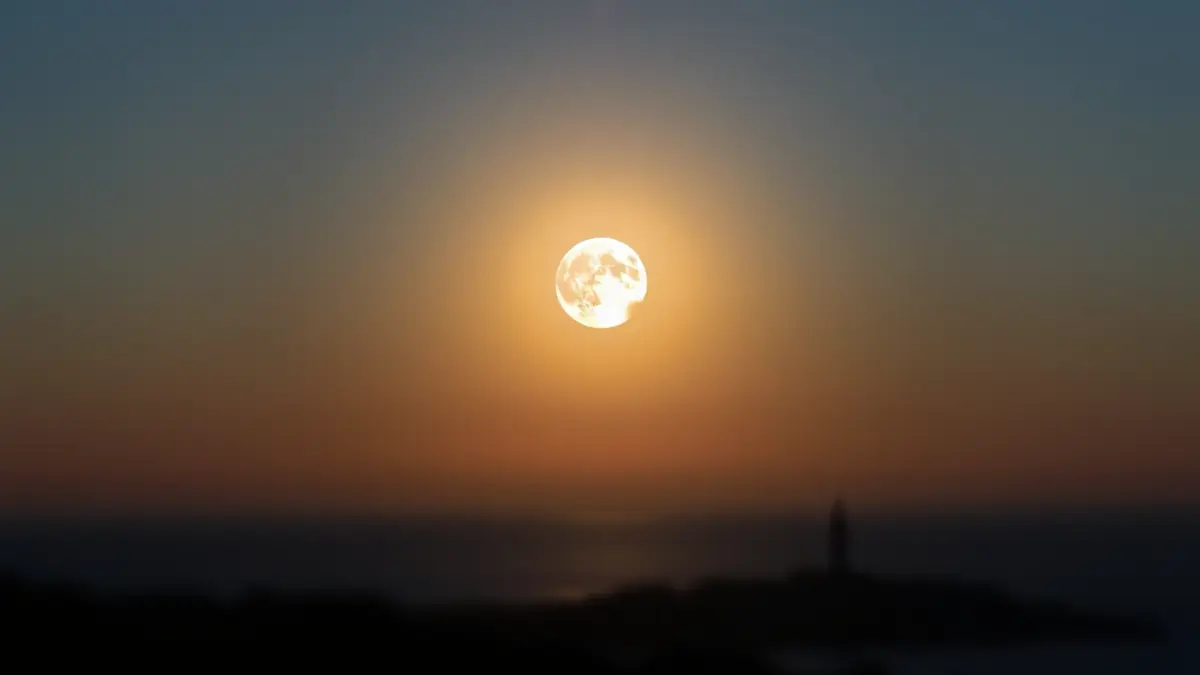 Imaxe dun eclipse solar parcial sobre unha paisaxe costeira galega.