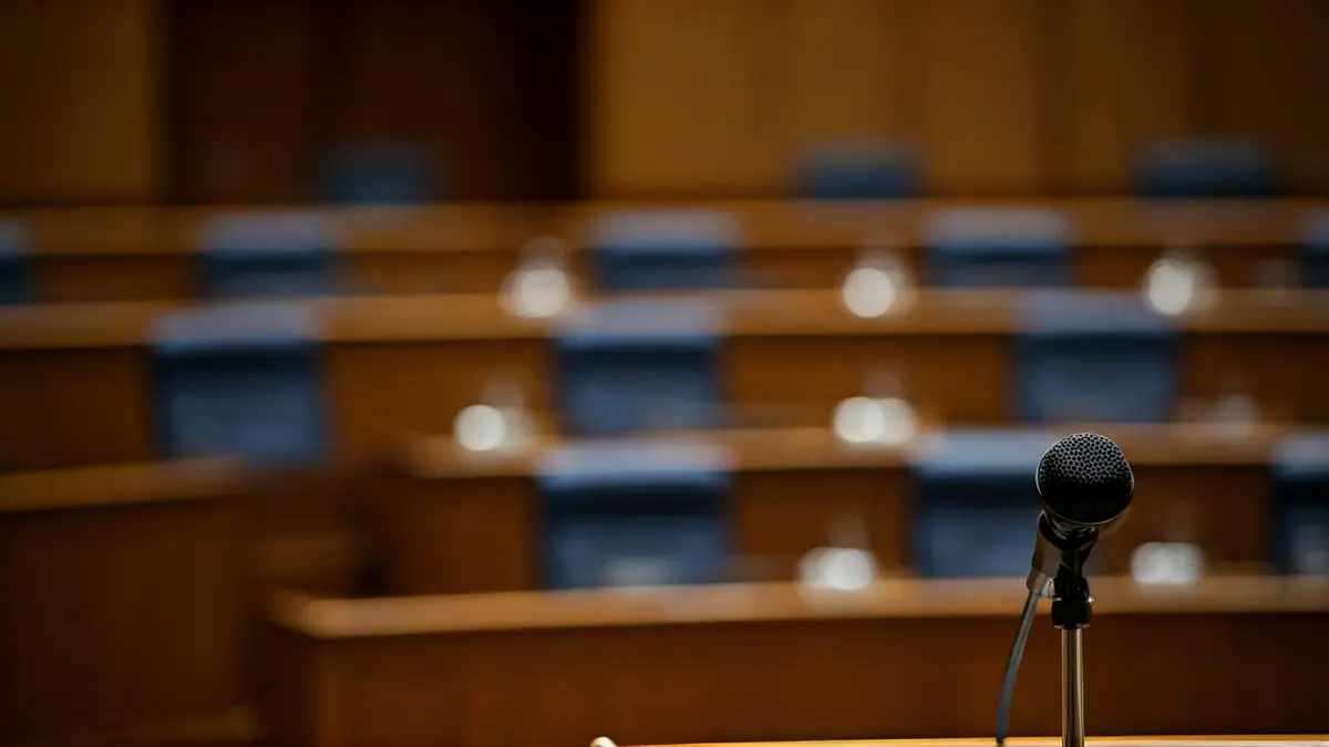 Imaxe xenérica dun micrófono nun atril, simbolizando un debate político.
