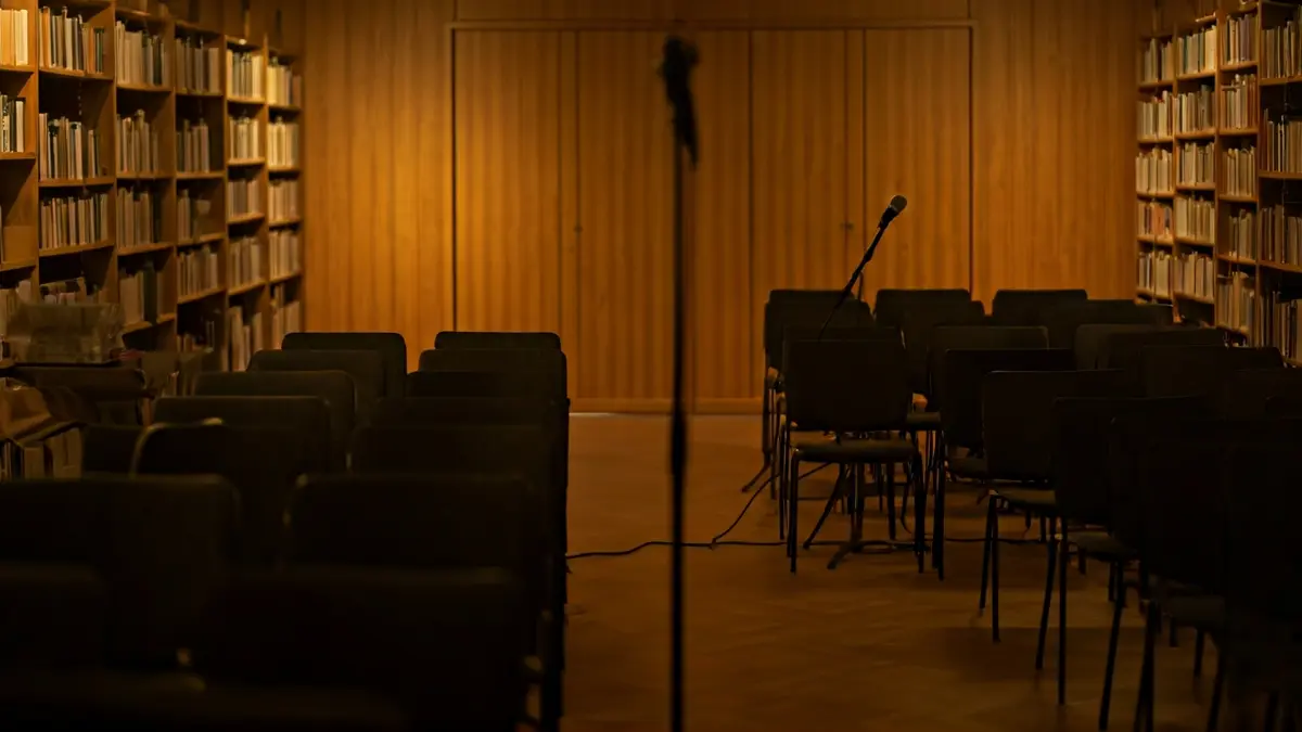 Imagen genérica de una sala de proyección o biblioteca, con asientos y un podio con micrófono.