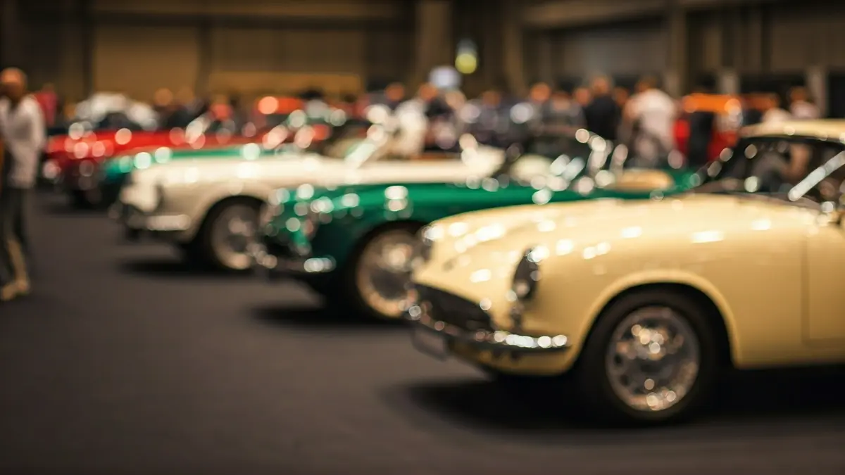 Imaxe xenérica dun salón de vehículos clásicos con coches antigos expostos.