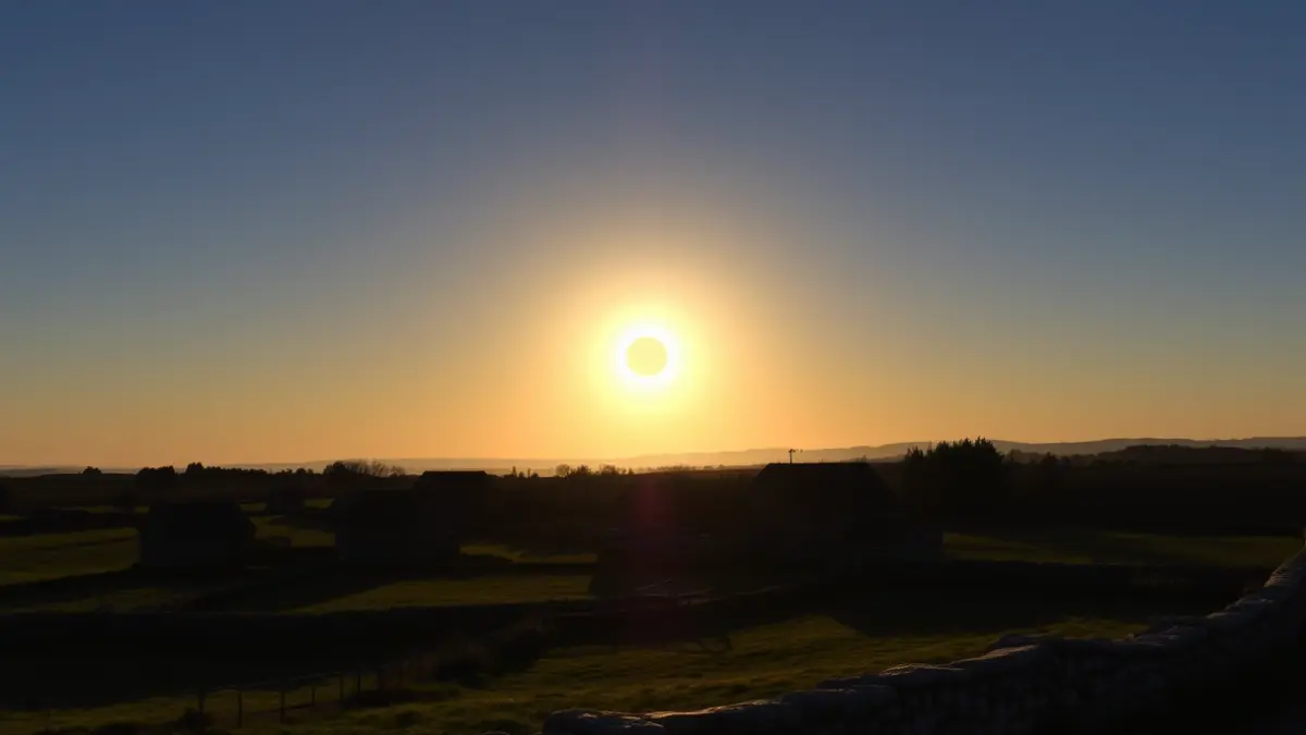 Imagen de un eclipse solar al atardecer sobre un paisaje gallego.