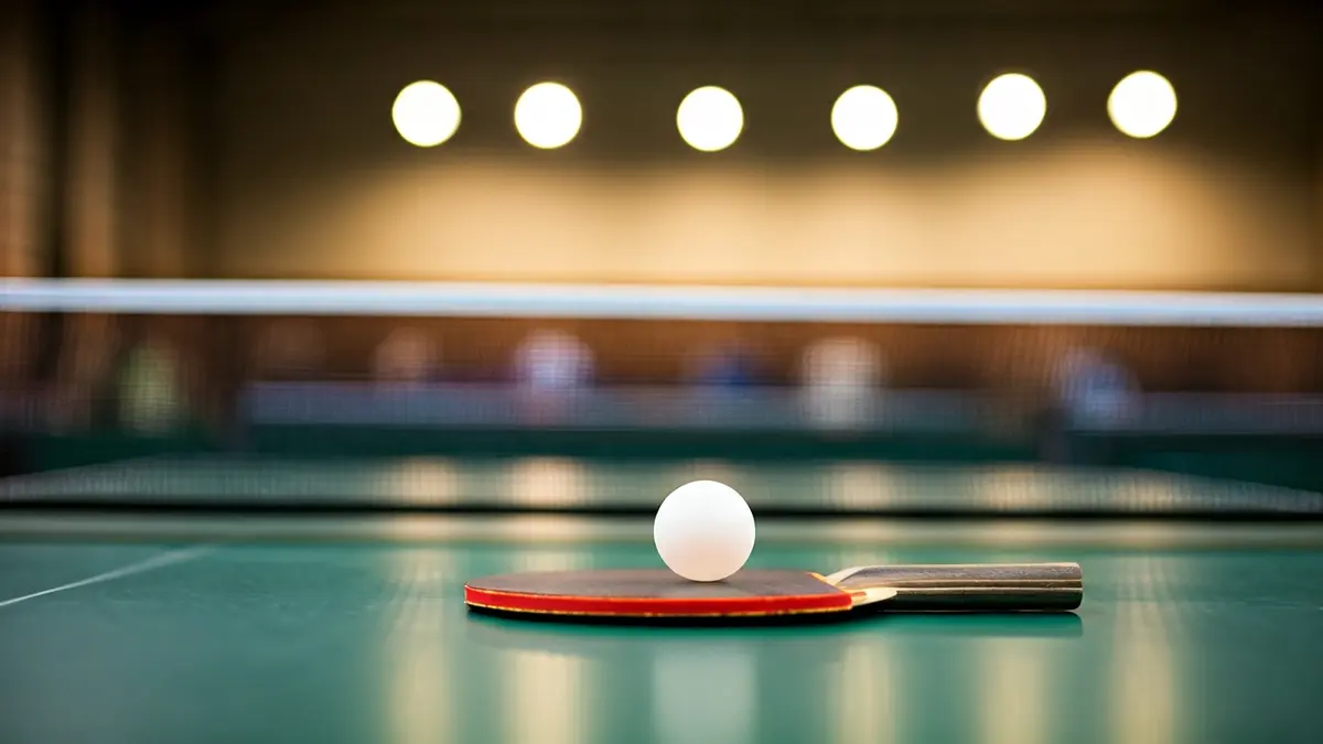 Imagen genérica de una raqueta y una pelota de tenis de mesa sobre una mesa verde.