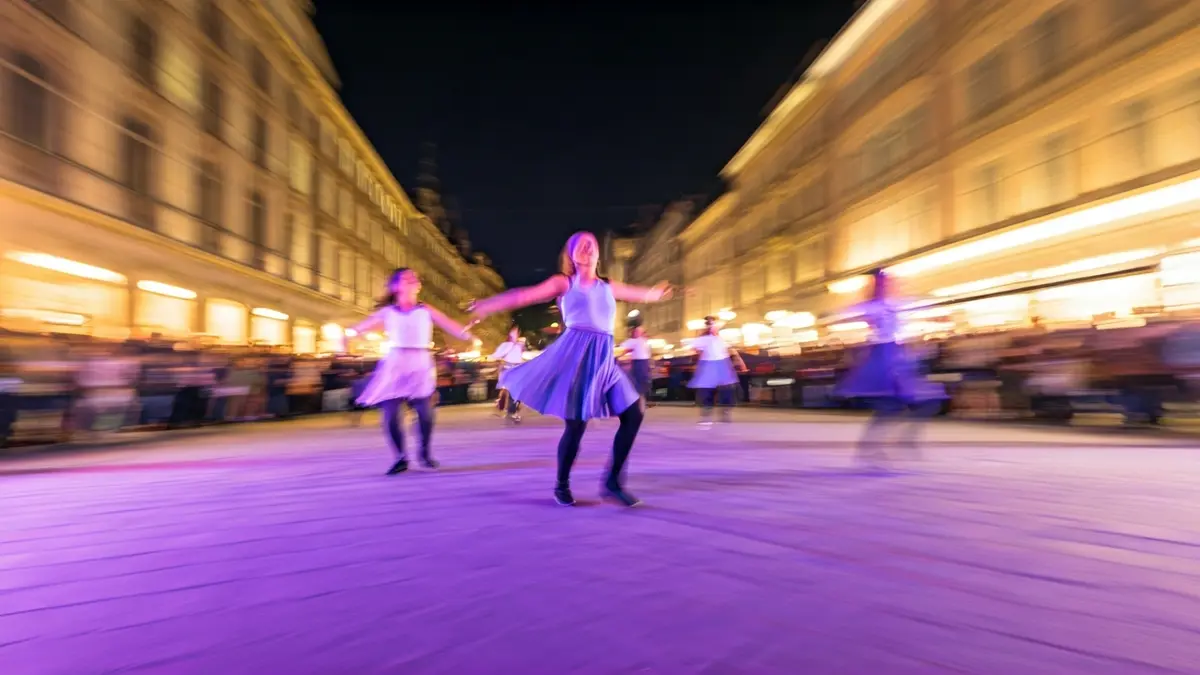 Imagen genérica de una actuación de danza en la calle, con movimiento y luces de colores.