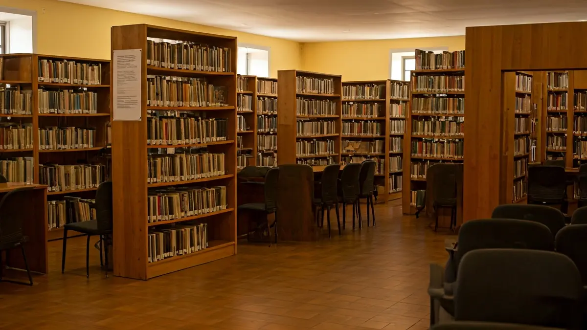 Imagen genérica de una sala de presentaciones literarias o biblioteca, con estantes de madera y un micrófono.