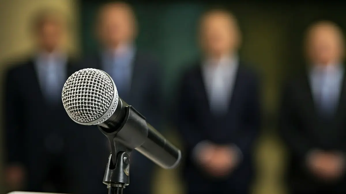 Imagen genérica de un micrófono en un atril durante una rueda de prensa.