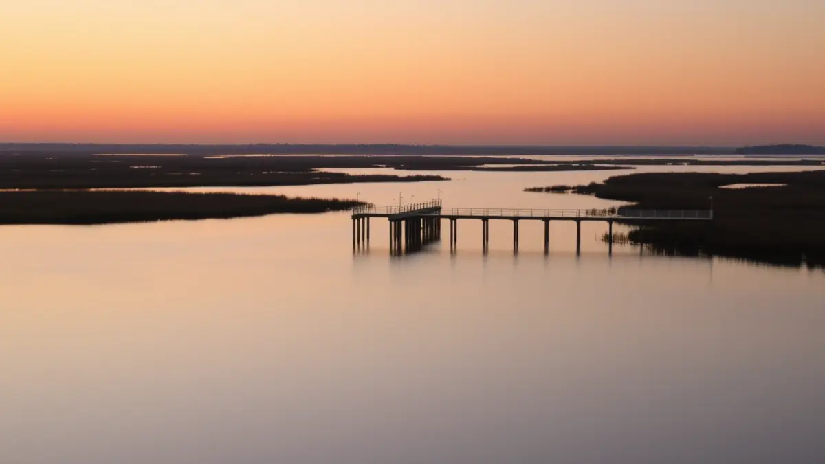 Imaxe dun novo dique fixo na ría de Ribadeo ao solpor, con embarcacións deportivas amarradas.