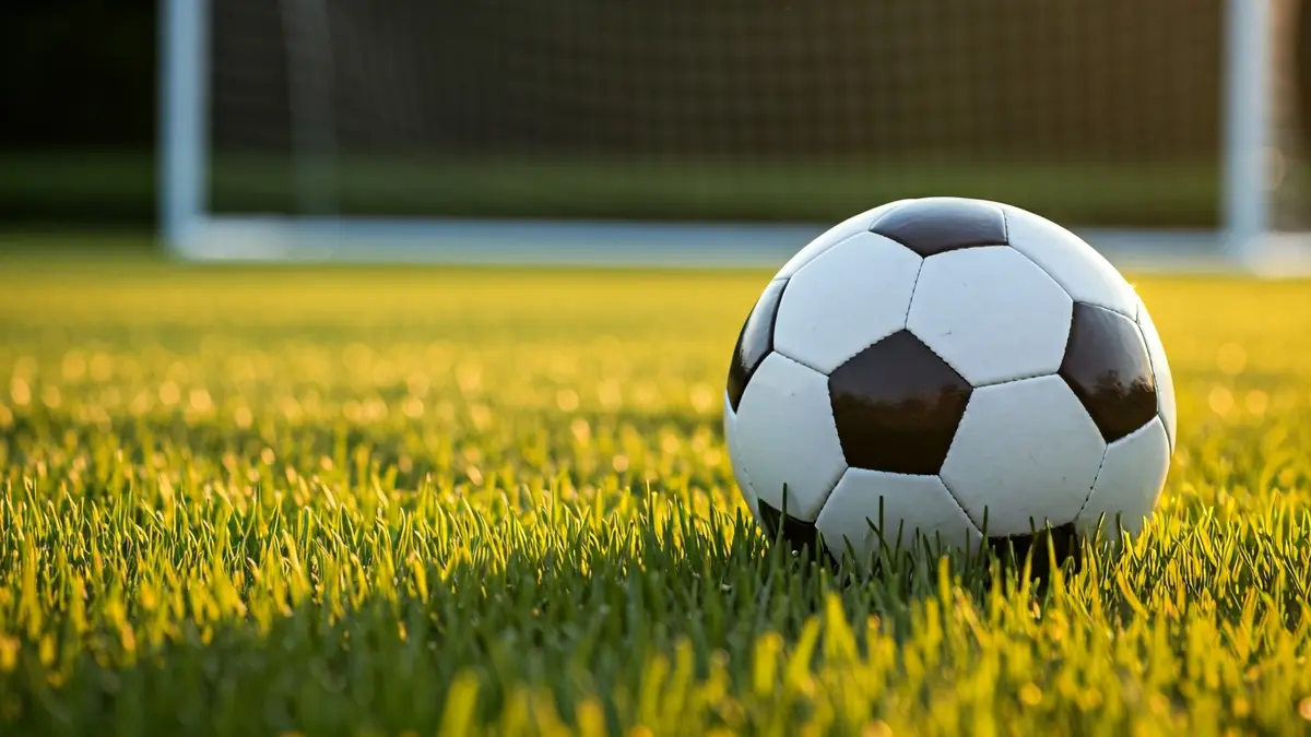 Imaxe xenérica dun balón de fútbol sobre a herba dun campo