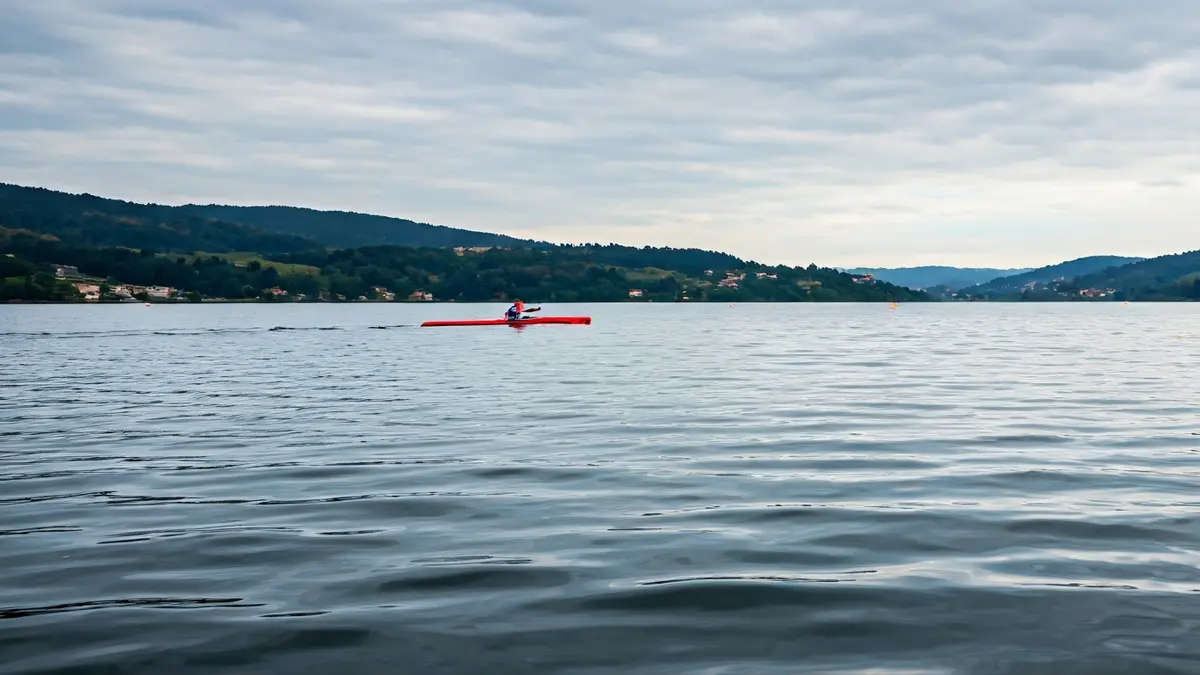 Imaxe xenérica dunha piragua navegando nun encoro, con paisaxe galega de fondo.
