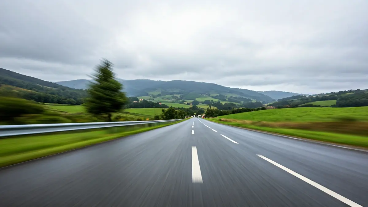 Imaxe xenérica dunha estrada galega con asfalto mollado e ceo cuberto.