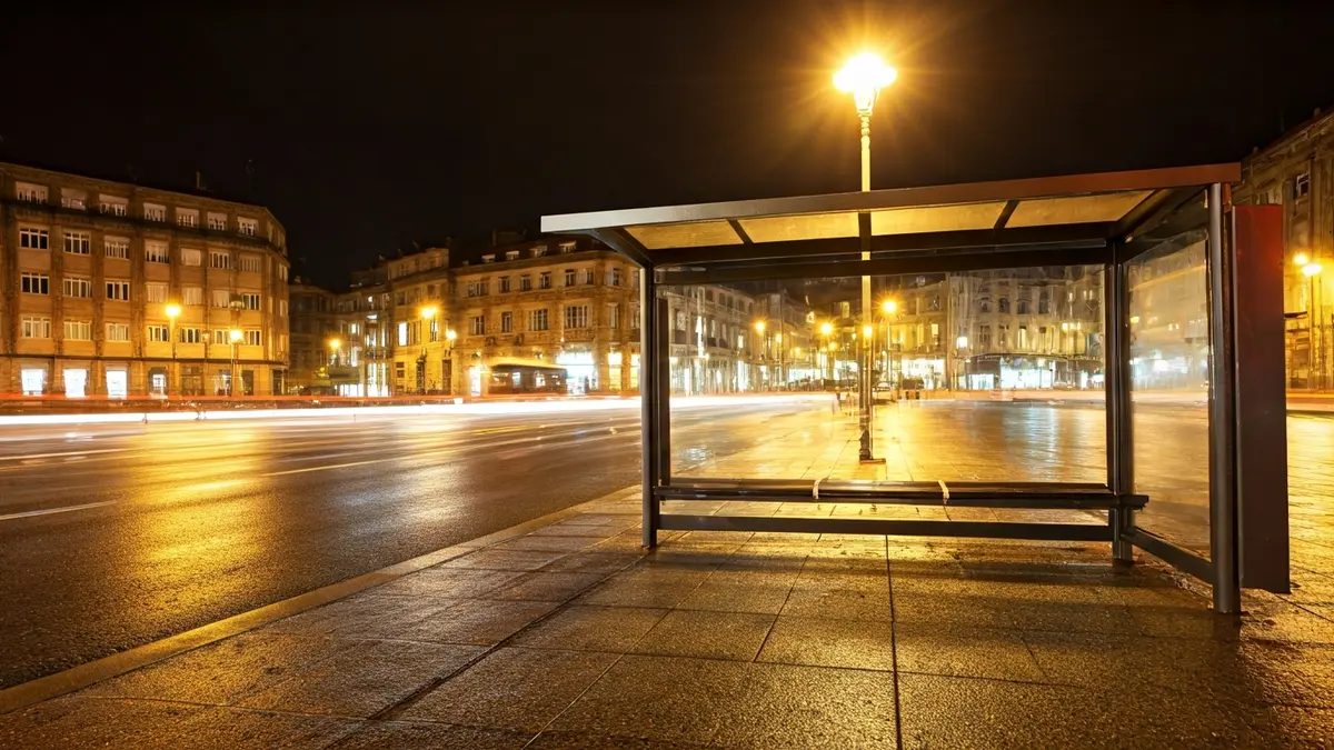 Imaxe xenérica dunha parada de autobús baleira pola noite nunha cidade galega.