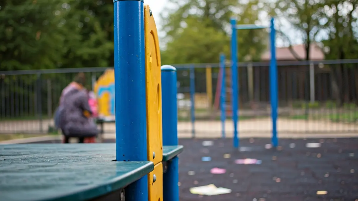 Imaxe dun patio de colexio con material educativo espallado polo chan.