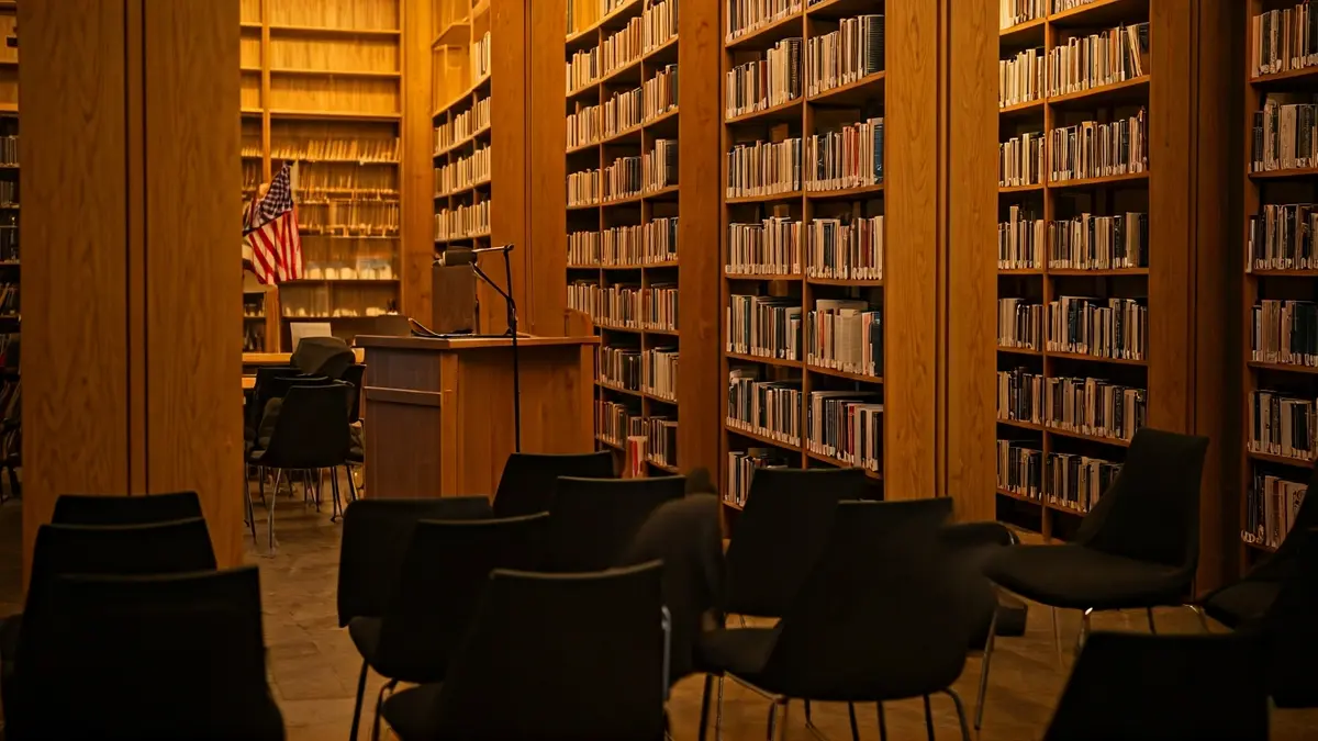 Imagen genérica de una sala de lectura o biblioteca con micrófono y sillas vacías.