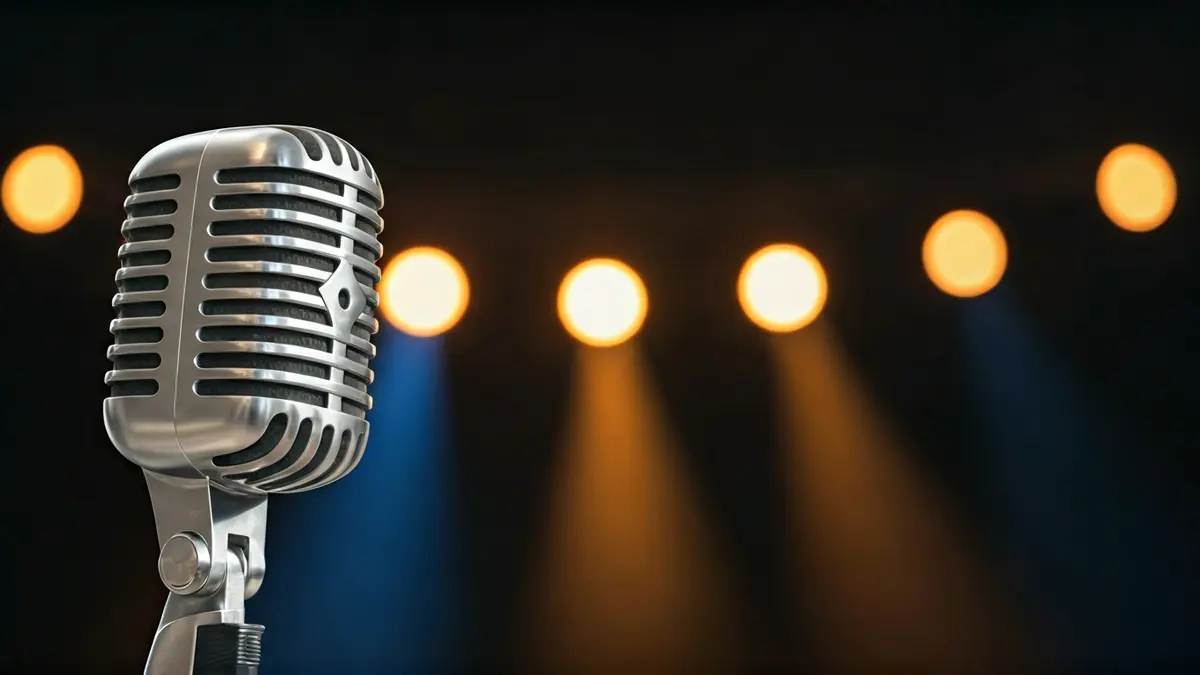Imagen genérica de un micrófono en un escenario, con luces de fondo borrosas.