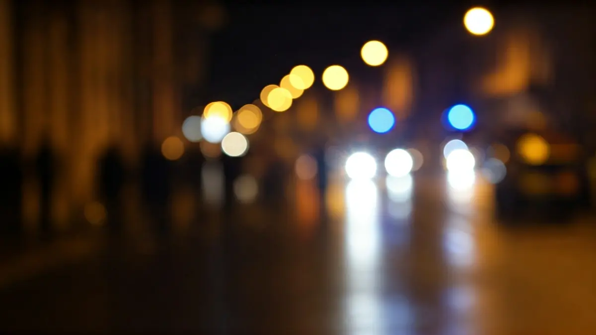 Imaxe xenérica de luces de emerxencia reflectíndose sobre asfalto mollado.