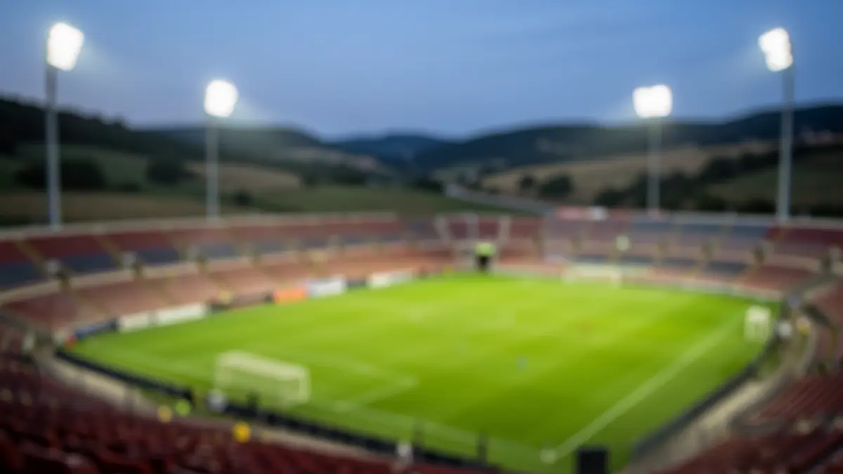 Imaxe xenérica dun estadio de fútbol baleiro ao anoitecer.