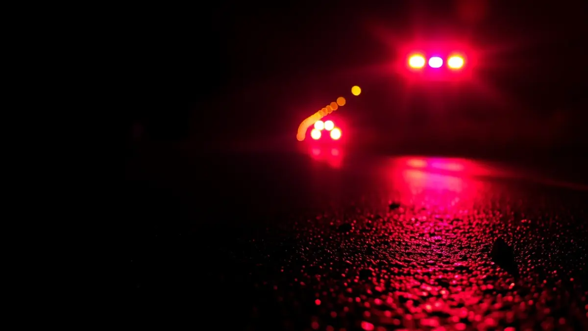 Imagen genérica de luces de emergencia reflejadas sobre asfalto mojado.