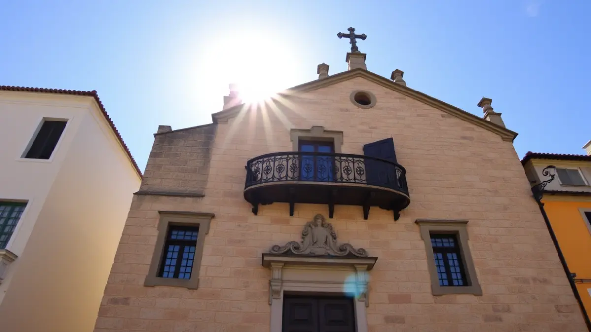 Fachada dun concello tradicional galego, con balcón e luz solar.