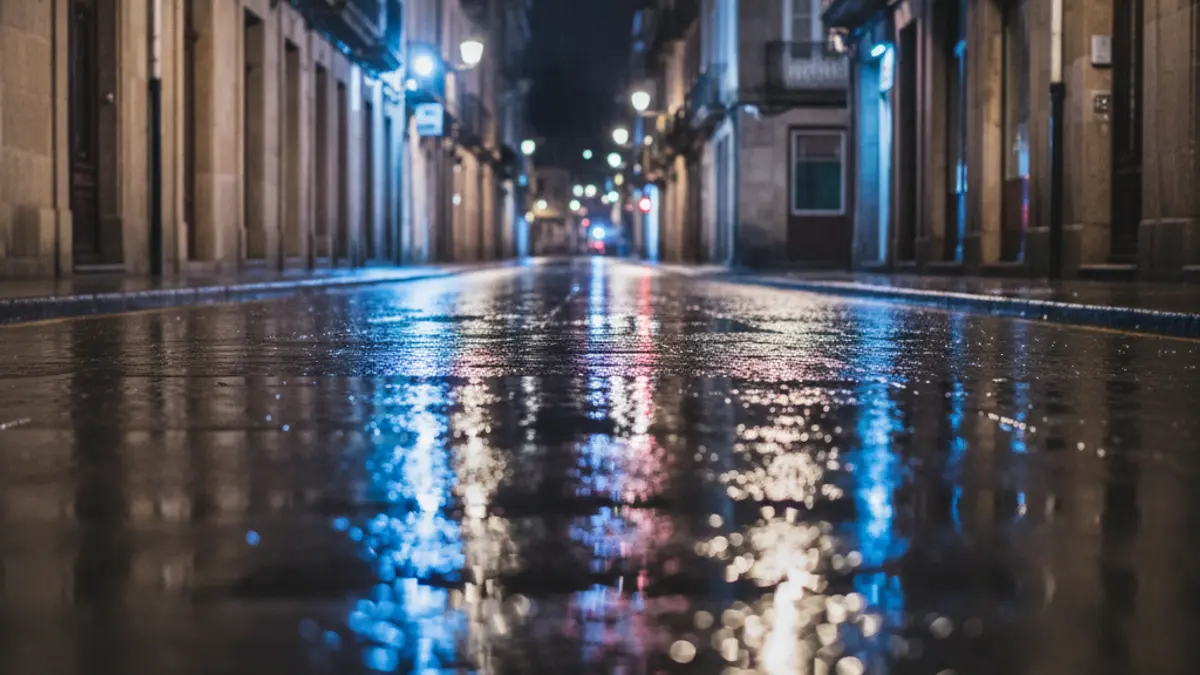 Imagen genérica de luces de emergencia reflejándose sobre asfalto mojado.