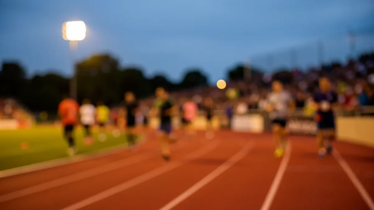 Imagen genérica de una carrera nocturna con luces artificiales y público difuminado.