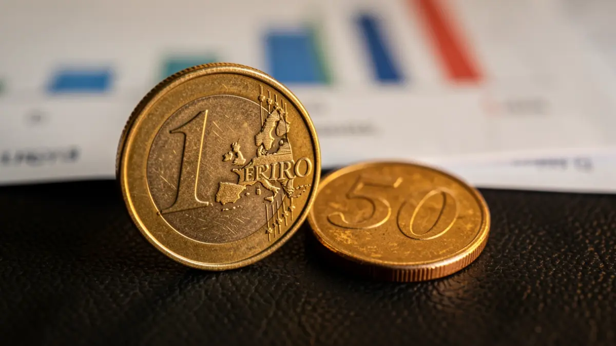 Primeira imaxe dunha moeda de euro e unha de 50 céntimos sobre fondo escuro.
