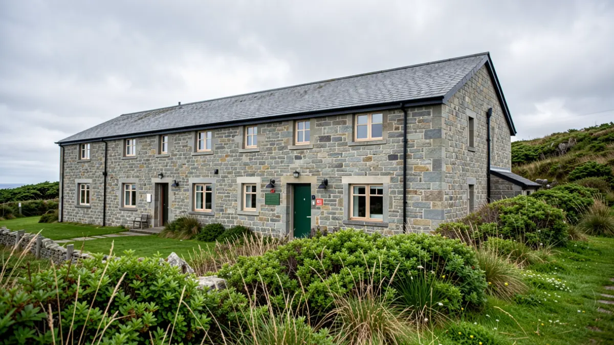 Imaxe xenérica dun albergue xuvenil galego con arquitectura de pedra e vexetación atlántica.
