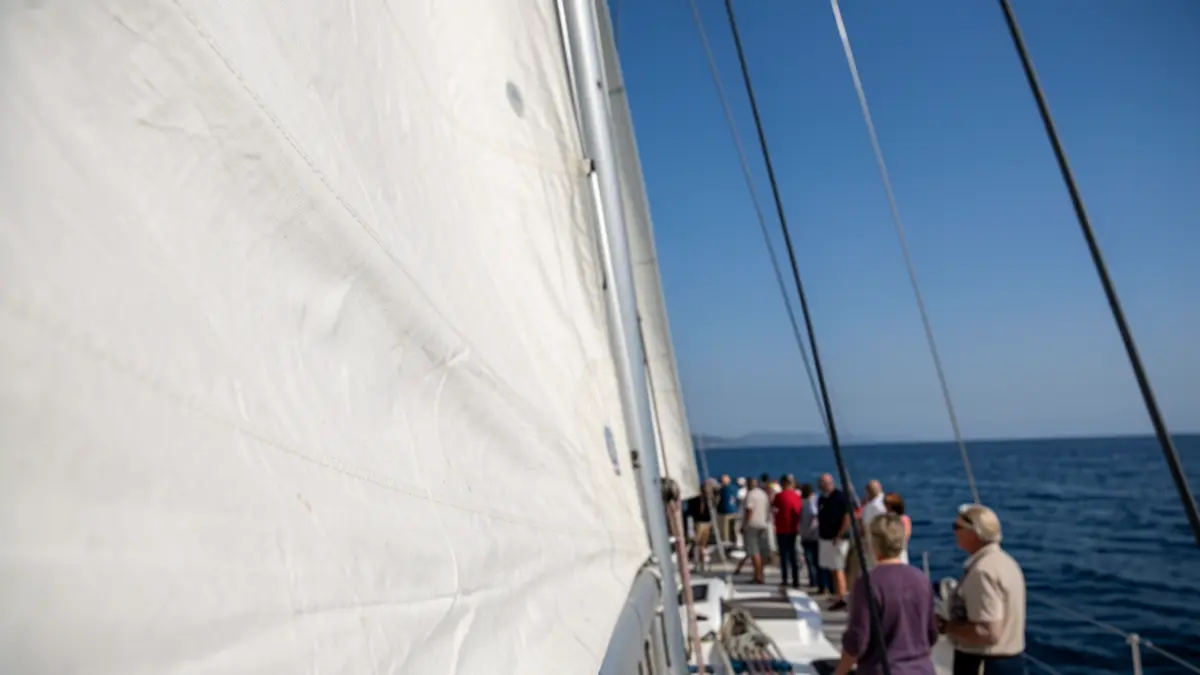 Imaxe xenérica dunha vela de barco de regata con ceo azul e mar.