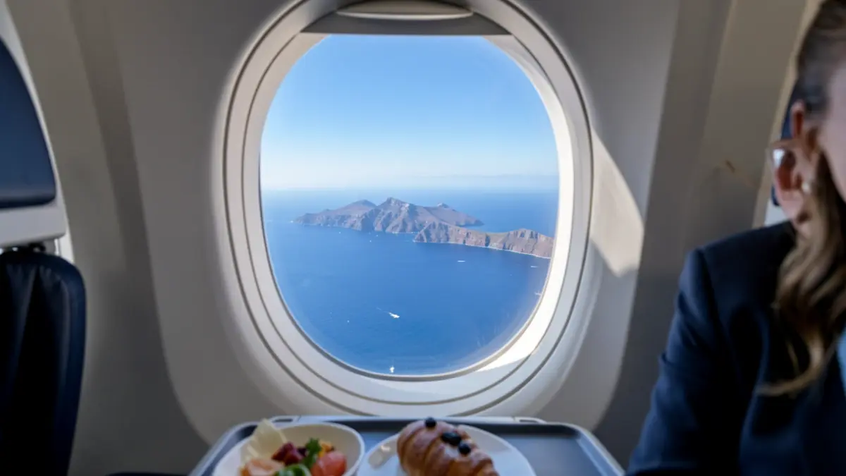 Imaxe dunha ventá de avión con vista das Illas Canarias e un aperitivo.