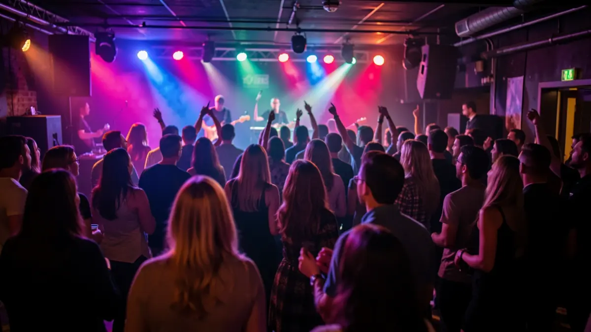 Imaxe xenérica dunha festa nunha sala de concertos con xente bailando e luces de cores.