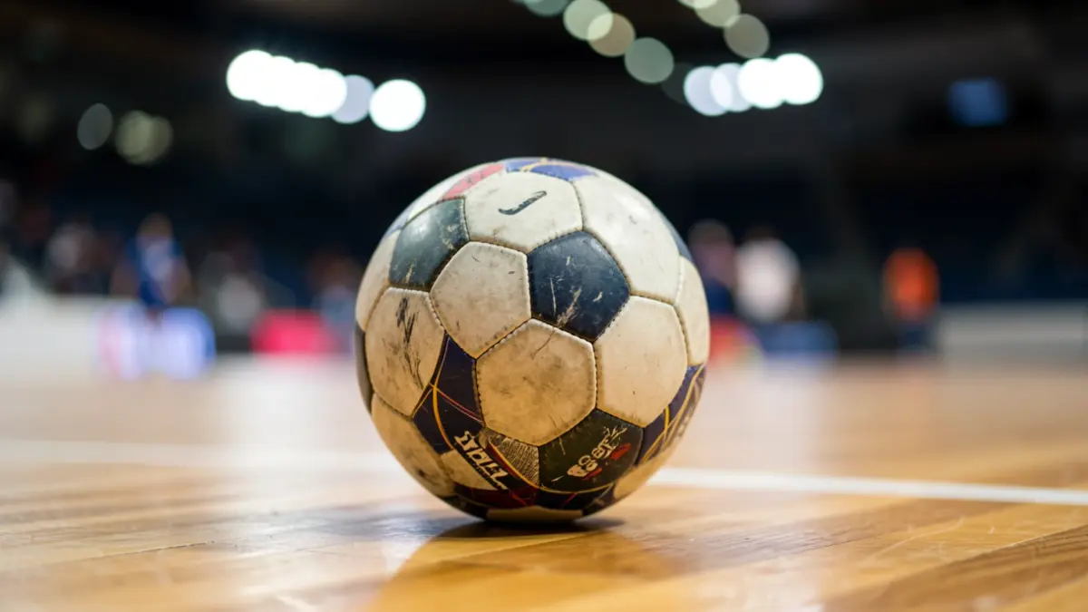 Imaxe xenérica dun balón de balonmán nunha cancha deportiva.