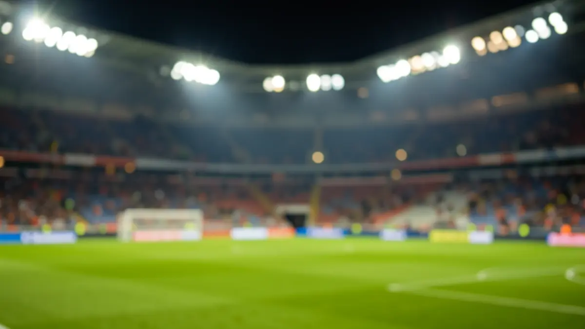 Imaxe xenérica dun estadio de fútbol pola noite, con luces borrosas e asentos baleiros.