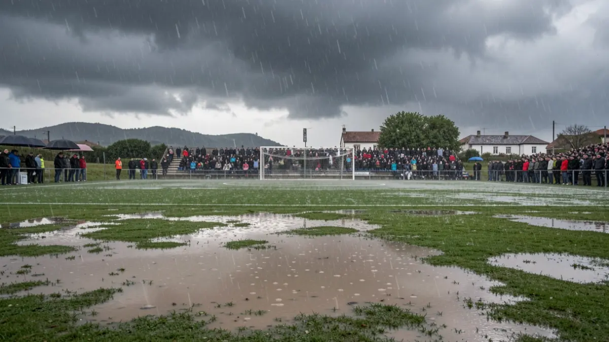 Imagen genérica de un campo de fútbol gallego bajo una fuerte lluvia, con grandes charcos de agua y nubes de tormenta.