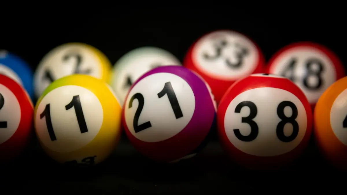 Primeros planos de bolas de lotería con los números 2, 11, 13, 21, 33, 48 visibles.