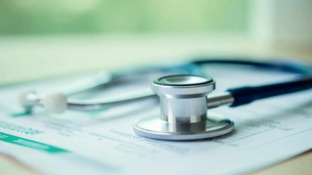 Imaxe xenérica dun estetoscopio sobre un informe médico.
