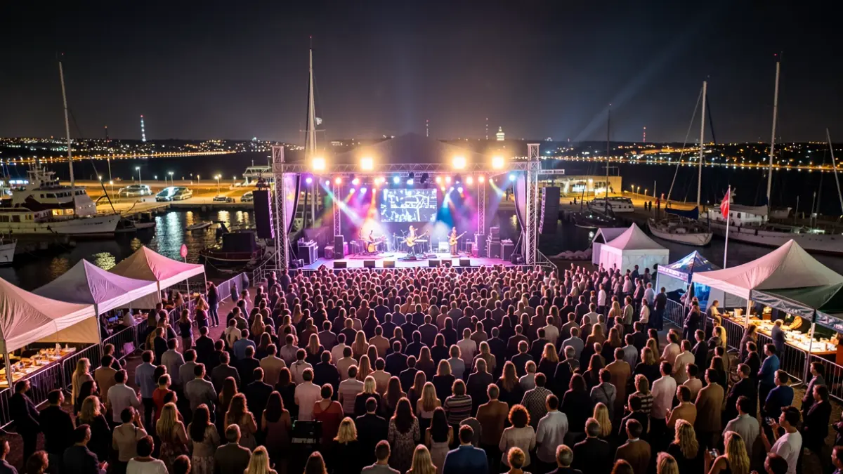 Imaxe dun festival de música ao aire libre no porto de Vigo con escenario iluminado e público.
