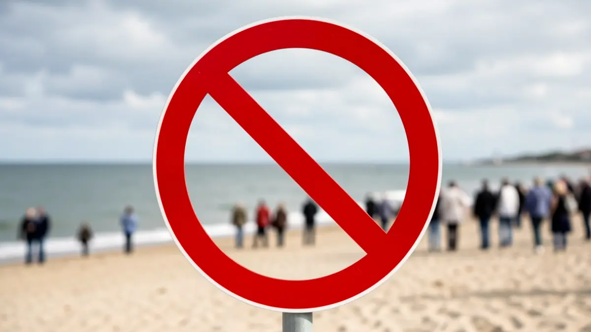 Imaxe xenérica dun sinal de prohibición de baño nunha praia.