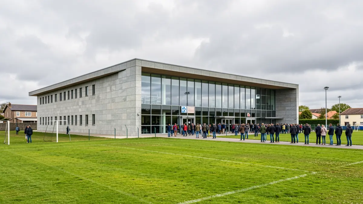 Imaxe xenérica dun pavillón deportivo municipal con fachada de granito e ventás grandes, baixo un ceo anubrado típico de Galicia.