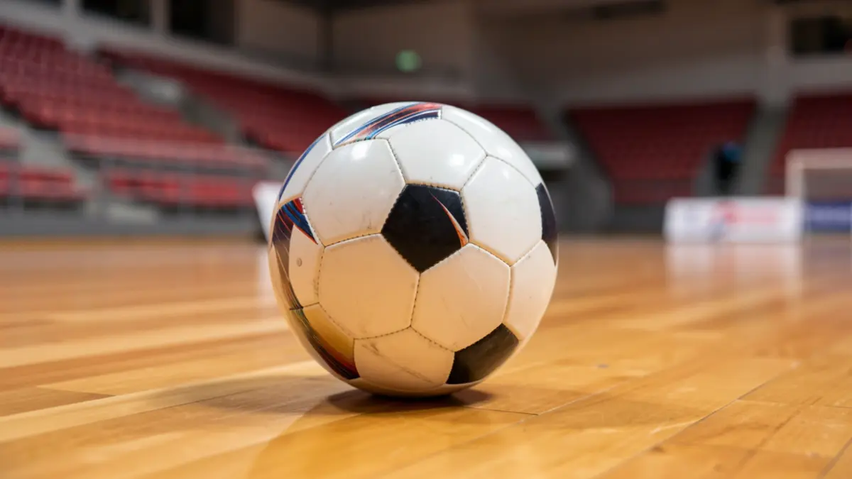 Imaxe xenérica dun balón de fútbol sala sobre unha pista deportiva.