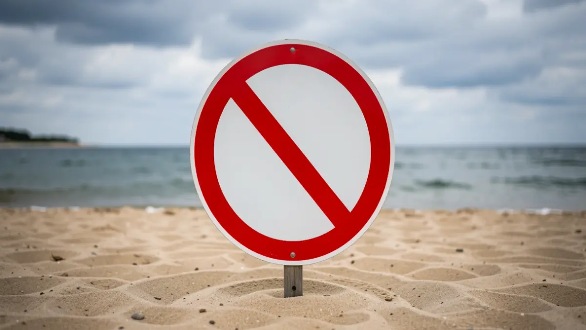 Imaxe xenérica dun sinal de prohibición de baño nunha praia.
