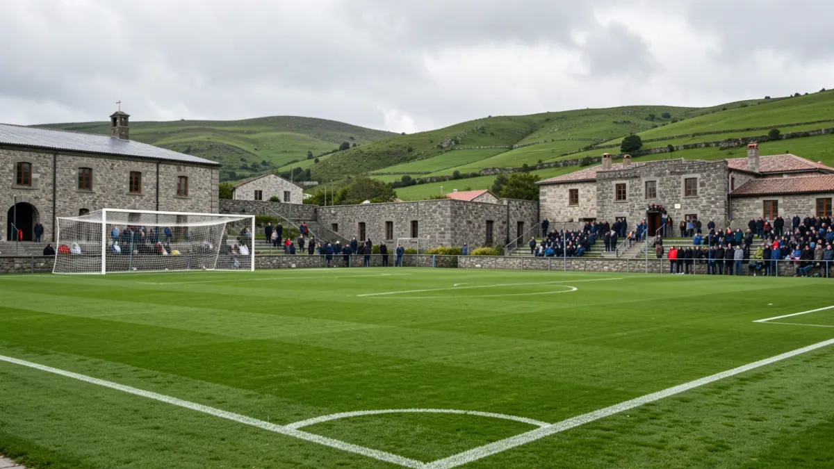 Imagen genérica de un campo de fútbol gallego con arquitectura de piedra y colinas verdes.