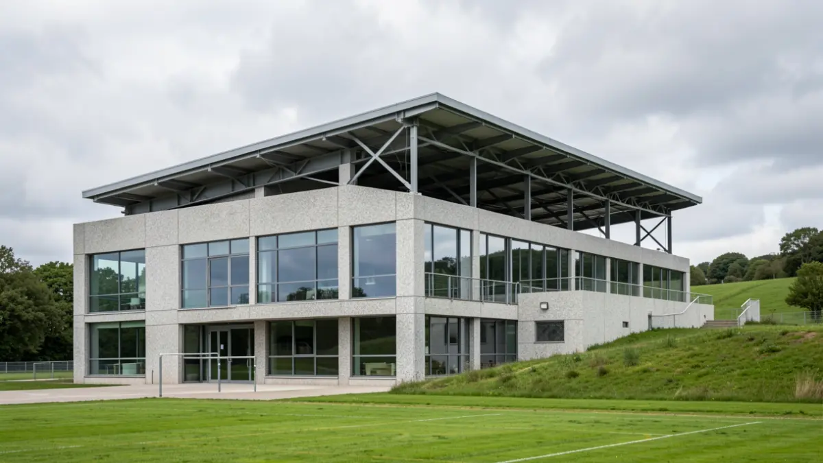 Imaxe xenérica dun pavillón deportivo de granito baixo un ceo nubrado en Galicia.